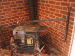 Woodstove hearth crane holding kettle 